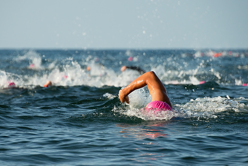 Group people in wetsuit swimming at triathlon